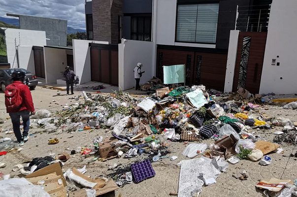 Trabajadores de limpia tiran basura afuera de la casa del alcalde de Oaxaca