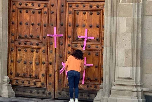 Mujeres colocan cruces en la puerta principal de Palacio Nacional