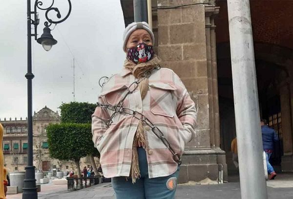 Mujer se encadena en el Zócalo en denuncia de falta atención médica para su hijo