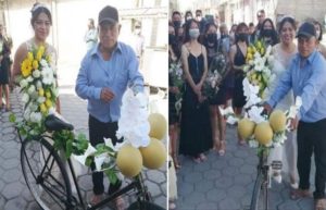 Padre lleva a su hija al altar en bicicleta adornada con flores, en Puebla