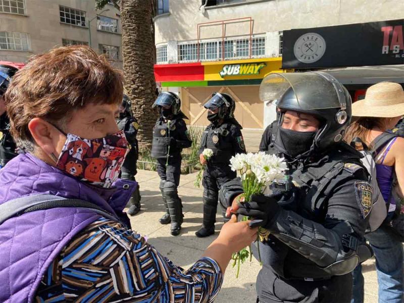 Mujeres dan flores a las policías en la marcha del #8M