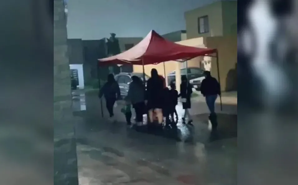 Con todo y lluvia, regios arman toldo para pedir dulces en Cadereyta, NL #VIDEO