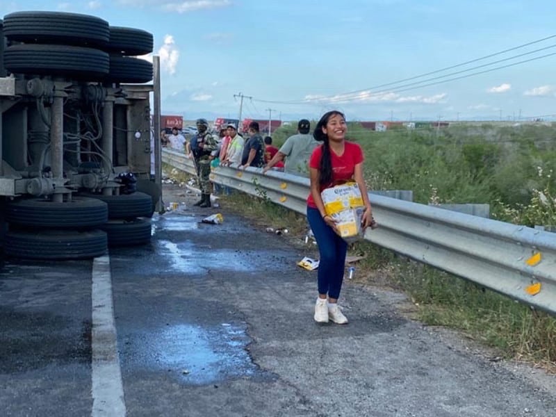 Un tráiler cargado de cerveza vuelca, y los residentes toman los cartones