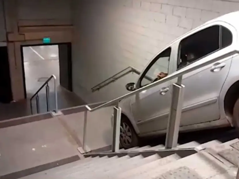 Se equivoca de salida y su auto queda atorado en las escaleras