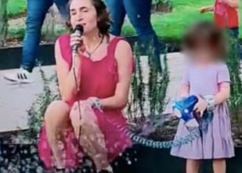 Mujer canta en parque mientras cuida a su hija