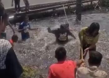 Familia nada en canal de aguas negras durante Semana Santa