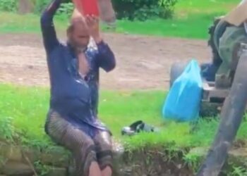 Hombre se baña en río de aguas negras