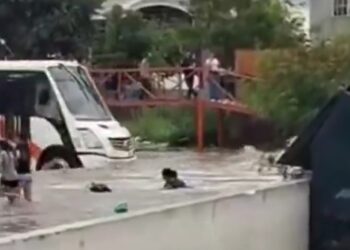 Niños nadan en calles inundadas entre camiones en NL